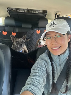 caregiver picking up Frenchie and beagle